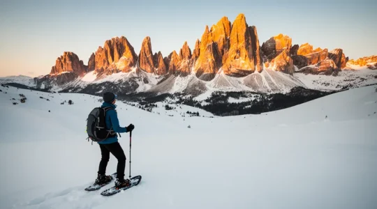 Escursionista principiante con ciaspole che ammira le Dolomiti innevate