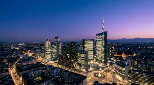 Vista panoramica dello skyline di Milano Porta Nuova durante l'ora blu con i grattacieli illuminati e il cielo crepuscolare