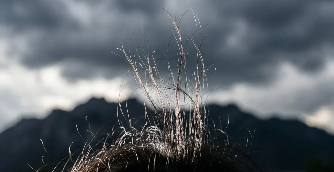 Primo piano di capelli che si sollevano per elettricità statica in montagna a causa di un temporale imminente
